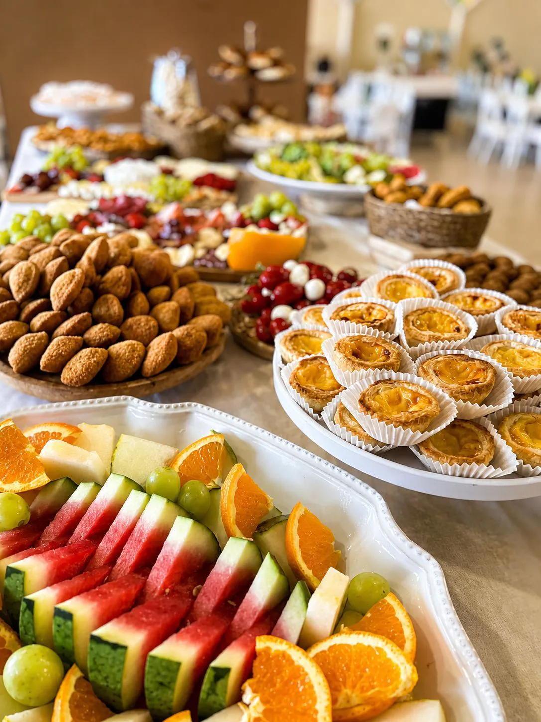 Mesa de catering com fruta fresca, pastéis e salgados